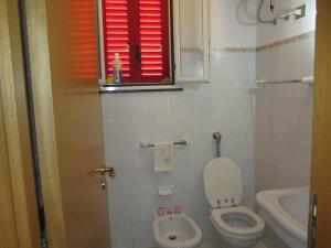 bagno con servizi igienici, lavandino e finestra di Villa Rosa a Case Monterosso