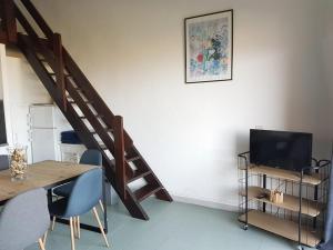 a living room with a staircase and a table and a television at Résidence Costa d'Oru in Saint-Florent