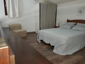 a bedroom with a bed and a chair at Résidence Costa d'Oru in Saint-Florent +73 photos