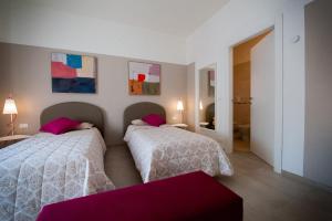 a bedroom with two beds with pink pillows at Daniela B&B Fiera in Pero