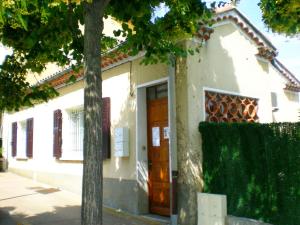 a white house with a brown door and a tree at 2 Chemin Neuf balcon in Gréoux-les-Bains