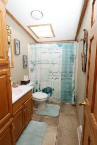 a bathroom with a toilet and a shower curtain at Island Club #98 in Put-in-Bay