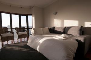 una camera da letto con un letto bianco, sedie e finestre di Cozy Beach Front with Rooftop a Vila do Conde