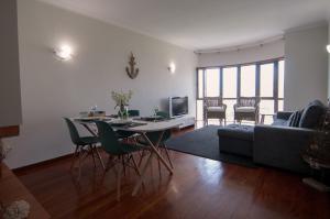 un soggiorno con un tavolo e un divano di Cozy Beach Front with Rooftop a Vila do Conde