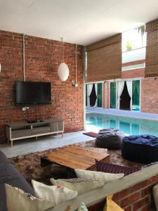 a living room with a brick wall and a swimming pool at Tanjung Rhu Pool Villa @ TRV in Huma