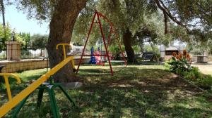 a park with a swing set next to a tree at Studios Evgenia Parga in Parga