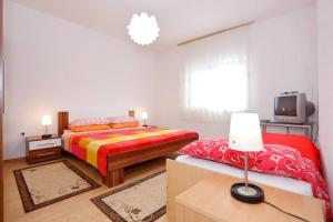a bedroom with two beds and a tv in it at Apartmani Mlinar in Gornji Karin