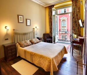 a bedroom with a bed and a balcony at Hotel Villa de Luarca in Luarca