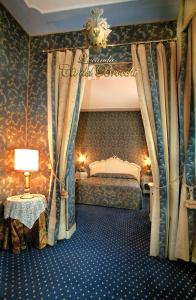 a bedroom with a canopy bed and a table with a lamp at Locanda Ca' del Brocchi in Venice