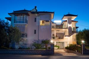 a white house with a fence in front of it at Studios Evgenia Parga in Parga