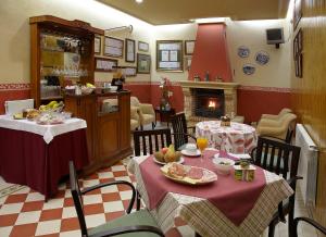 a dining room with two tables and a fireplace at Hotel Villa de Luarca in Luarca