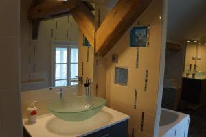 uma casa de banho com um lavatório de vidro num balcão em Chateau de Savennes - Caveau de sabrage em Savennes