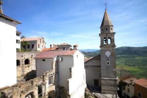 a church with a steeple on top of a building at Loggia Motovun in Motovun