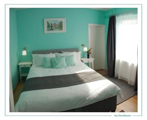 a bedroom with a large bed with blue walls at Joy Guesthouse in Siófok