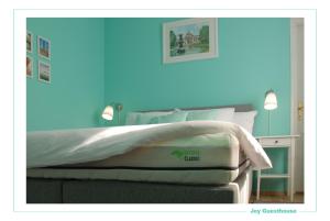 um quarto com uma cama com uma parede azul em Joy Guesthouse em Siófok