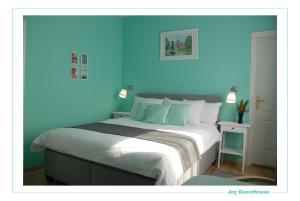 a blue bedroom with a bed with a blue wall at Joy Guesthouse in Siófok