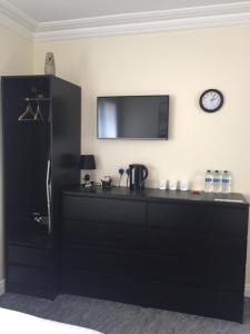 a kitchen with a black counter and a tv on the wall at Citi North in Belfast
