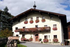 un gran edificio blanco con cajas de flores. en Palfnerhof Appartements, en Sankt Johann im Pongau