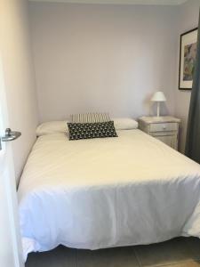 ラスパルマス・デ・グランカナリアにあるBeach line apartmentのベッドルーム(白いベッド1台、黒い枕付)
