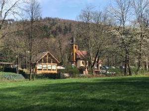 une maison avec une tour au sommet d'un champ verdoyant dans l'établissement Bukowy Las, à Jaworze