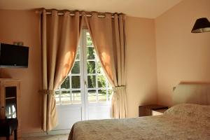 una camera con un letto e una grande finestra di Hotel Les Mazets Des Roches a Tarascona