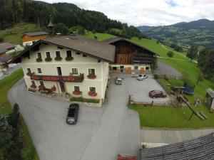 Una vista aérea de una casa grande con estacionamiento. en Palfnerhof Appartements, en Sankt Johann im Pongau 27 fotos más