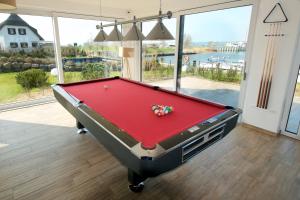 a pool table in a room with a view of the water at mönchgut living & spa in Gager