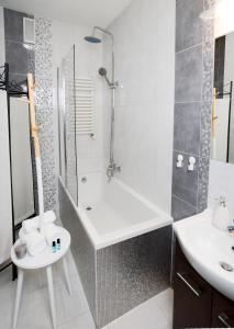 een badkamer met een douche, een bad en een wastafel bij Vinyl Apartment Old Town in Krakau +6 foto's