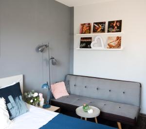 een slaapkamer met een bank, een bed en een tafel bij Vinyl Apartment Old Town in Krakau