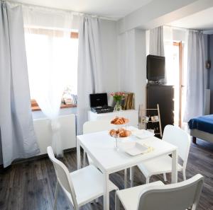 uma sala de jantar branca com uma mesa e cadeiras brancas em Vinyl Apartment Old Town em Cracóvia