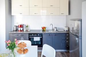 uma cozinha com armários azuis e uma mesa com um prato de pão em Vinyl Apartment Old Town em Cracóvia