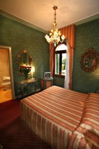 um quarto de hotel com uma cama e um espelho em Locanda Ca' del Brocchi em Veneza