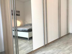 ヴァーネミュンデにあるApartment Warnemünde 14の鏡付きのベッドルーム1室、ベッド1台が備わるベッドルーム1室を提供しています。