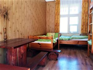 ストロニエ・シロンスキエにあるZbójnicki Ostępのベッド2台、テーブル、窓が備わる客室です。