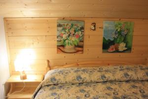 a bedroom with a bed with paintings on the wall at Albergo Diffuso Faller in Faller