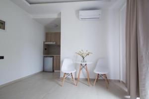 a white kitchen with a table and two chairs at Xenia Stalis Apartments in Stalís