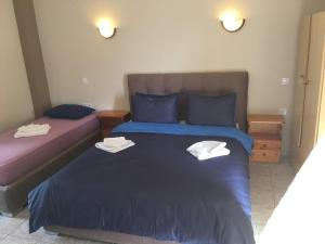 a bedroom with two beds with towels on them at Kastraki Studios in Stoupa