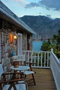 a patio with a table and chairs on a deck at Losta Sahil Evi 2 in Selimiye
