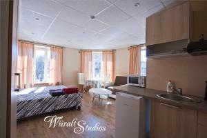 cocina y sala de estar con cama y lavamanos en Wiiralt Studios, en Tallin