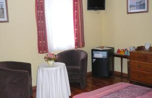 a room with chairs and a table with a vase of flowers at Le Bernister parking privé in Malmedy