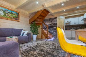 a living room with a couch and a kitchen at Domek z widokiem-Deluxe Cottage with a View Deluxe-Zakopane in Zakopane