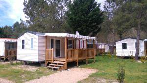 uma pequena casa branca com um alpendre e um deque em Les Dunes de Contis em Saint-Julien-en-Born