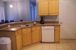 a kitchen with wooden cabinets and a sink and a dishwasher at Walts Magical Getaway in Davenport