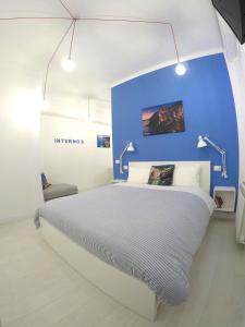 1 dormitorio con 1 cama en una pared azul en Interno5 Apartment, en La Spezia