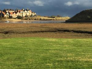 a field of green grass with houses in the background at Estuary View Caravans in Alnmouth