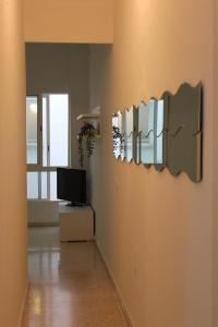 a living room with a tv and a wall with mirrors at Apartamento Alfaqueque in Seville