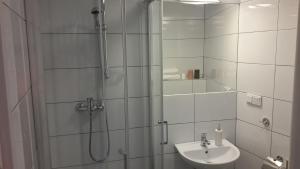 a bathroom with a shower, sink, and mirror at Cracow Central Aparthotel in Kraków