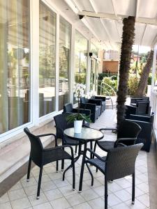 a patio with tables and chairs on a porch at Hotel Negresco in Riccione