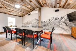 una sala conferenze con tavolo, sedie e murale di montagna di A-Lodge Boulder a Boulder Altre 37 foto