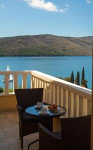 einen Tisch und Stühle auf einem Balkon mit Blick auf das Wasser in der Unterkunft Apartment Punta in Seget Vranjica